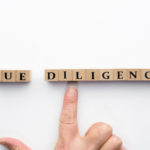 デューデリジェンスの文字ブロックを指差す