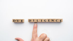 デューデリジェンスの文字ブロックを指差す