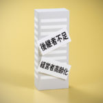 後継者不足と経営者高齢化のレッテルが貼られたビルの模型