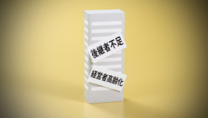 後継者不足と経営者高齢化のレッテルが貼られたビルの模型